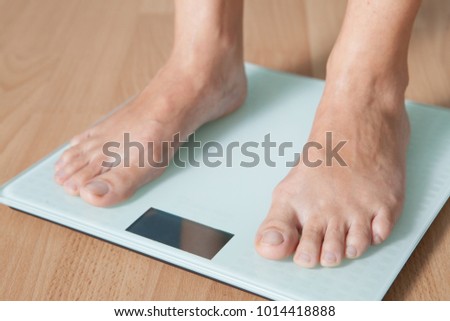 Legs of a young woman on a digital scale. Checking the weight. The concept of weight loss.