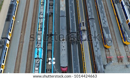Aerial top down picture of railway hub and parked passenger trains next to each other moving slowly over the rail vehicles with different colors beautiful rail network