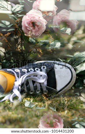 beautiful double exposure photography of a black and white sneakers shoes with delicate soft pink roses 