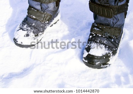 children's winter boots on white snow