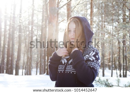 Portrait of blonde girl in winter forest. Concept winter vacation.