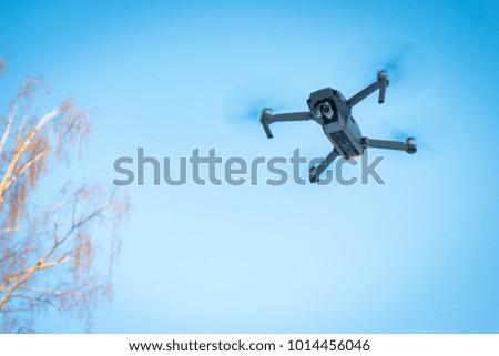 Drone flying in the blue sky, unmanned copter flight, 