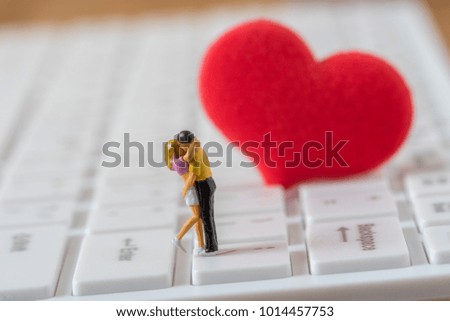 couple of miniature figure lover and big red heart on white computer keyboard  background