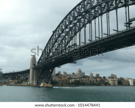 Steel bridge and ferry before shore with residential houses in Sydney Australia 