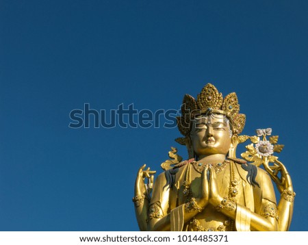 Golden Buddha statue in Kathmandu, Nepal, with clear blue sky in the background