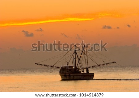 A shrimp boat off St Simons Island, Georgia at sunset. Royalty-Free Stock Photo #1014514879