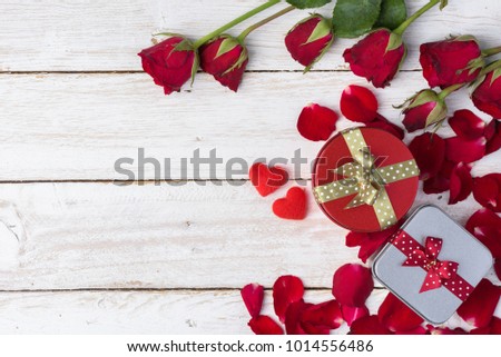 Red roses/petals and gift box on old white wood table/Valentines day background
