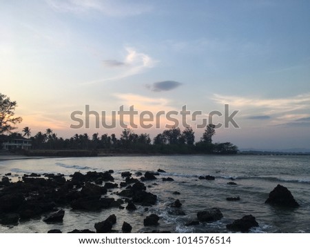 Silhouette photo of beautiful sunset seascape during twilight time with many rocks.Beach sunset concept.