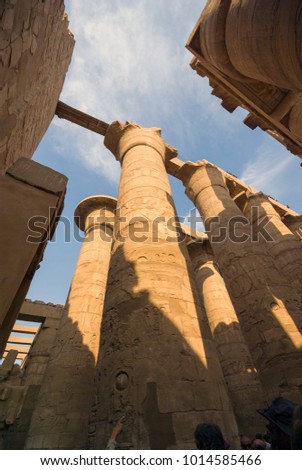 View from below the ruins of the huge columns of the Luxor temple in the hypostyle hall full of hieroglyphic images, in Egypt