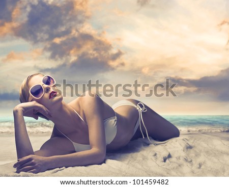 Beautiful woman in bikini lying on a beach