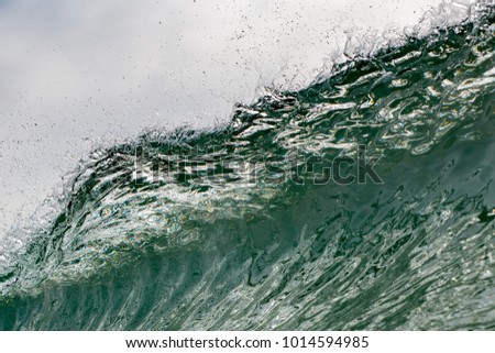 Wave during cloudy day with sharp lips and glass like surface