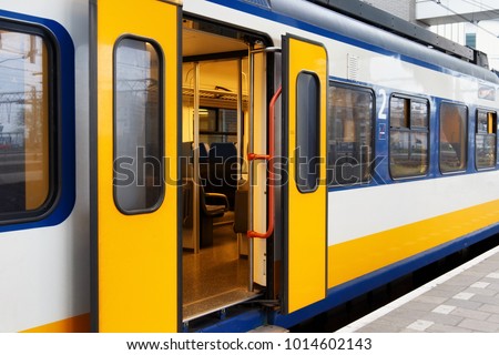 Yellow Dutch train on the Amsterdam Centraal station platform in morning. Centraal is the largest railway station of Amsterdam, Netherlands and a major national railway hub. Royalty-Free Stock Photo #1014602143