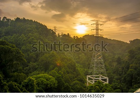 high voltage power line through a valley inside deep jungle