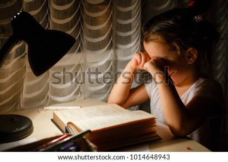 Beauty attractive little girl looking at all homework feeling bored and unhappy when she preparing