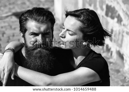 Young couple of beautiful brunette woman and handsome man hipster with beard hug outdoors on sunny day
