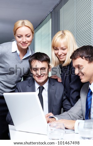 Four business people working with laptop in office