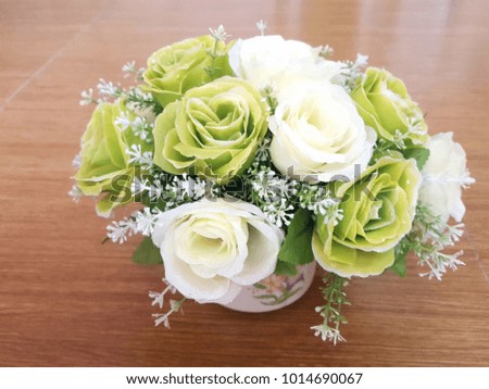 Artificial white and green color flower with orange concrete background