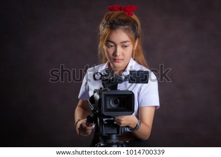 Cameraman,girl in university uniform she make television broadcast in studio.
