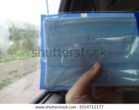 Medical Concept, Hand Holding Surgical Masks or Procedure Masks in Clear Plastic Pack For Protection Against Bacteria Shed in Liquid Droplets and Aerosols in The Mouth and Nose.