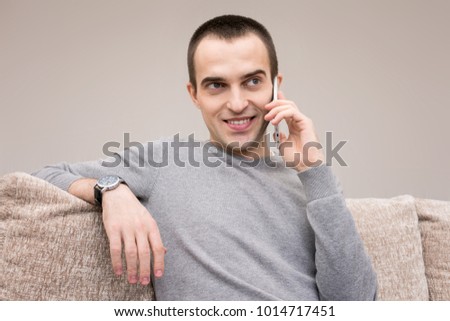 man smiling talking on smart phone, front view, isolated