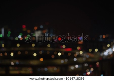 Defocused urban abstract texture bokeh city lights & traffic jams in the background with blurring lights on the top of mountain.