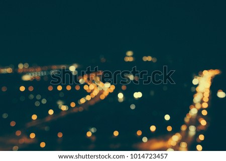 Defocused urban abstract texture bokeh city lights & traffic jams in the background with blurring lights on the top of mountain.