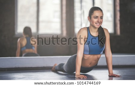 Attractive young sport girl is doing yoga in light room. Healthy lifestyle concept.
