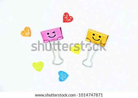 Colorful heart, pink and yellow binder clips on white background for valentine