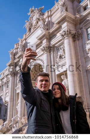 Young couple, taking a selfie with the Trevi fountain in the background