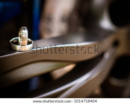 the wedding rings are on the rim of the car, this is a cool picture and a great idea