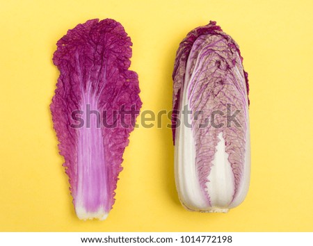 Minimal style, creative concept of fashion food. Flat lay. Food concept. Purple Chinese cabbage on a bright yellow background, top view