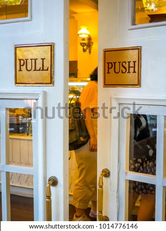 Close up Push-push signage. Vintage style door with square decorative window . Beautiful warm yellow light. Selective focus. 