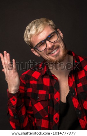 Man in red shirt in cage with glasses on black background