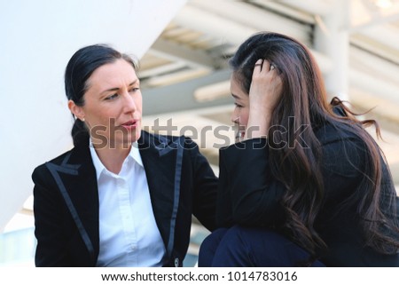 Businesswoman consoling her friend that suffering from headache about problem working, female is frustrated about work and friend's hand on shoulder of colleagueat outside building  Royalty-Free Stock Photo #1014783016