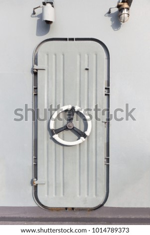 Iron door on top deck of ship, unlock by loosen the wheel.