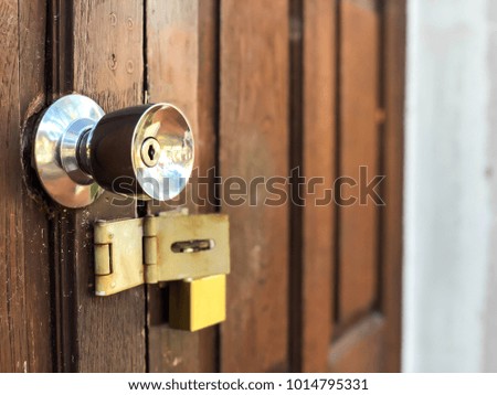 Stainless steel door knob and lock on old vintage wooden door. Selective focus.
