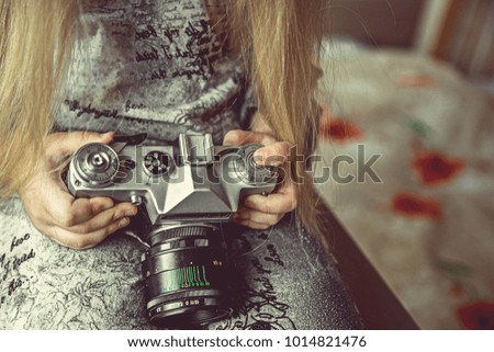 the child is holding a camera in the hands of a close-up