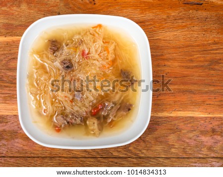 top view of traditional russian soup with stewed sour cabbage in ceramic plate on wooden table