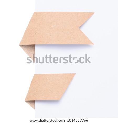 Two curved ribbons from ecological recycled paper bend over white paper corner isolated on white background
