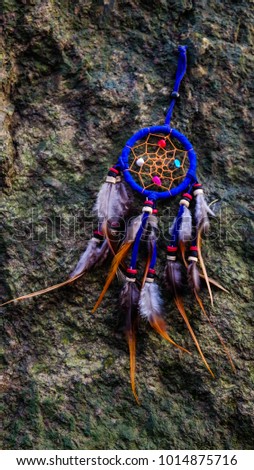 Native American Dreamcatcher on rock background, believe