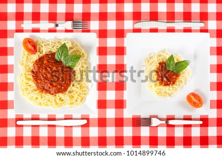 Contrasting large and tiny food portions of Spaghetti Royalty-Free Stock Photo #1014899746