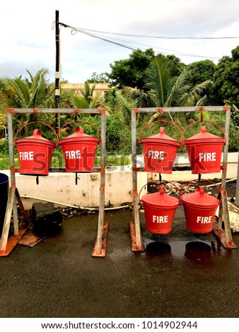 Metal buckets with water in case of fire. Gas station at Mauritius island, Africa