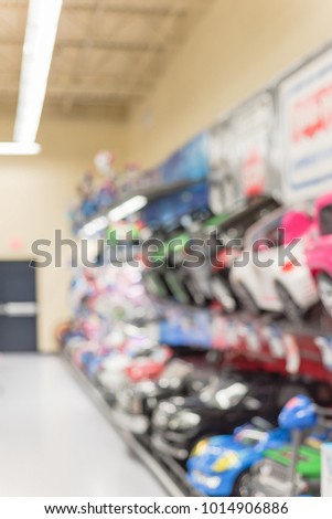 Blurred row of ride-on toy cars at toy retailer store in America.