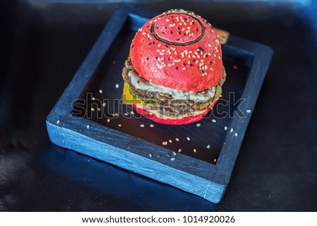 Red burger on a wooden board