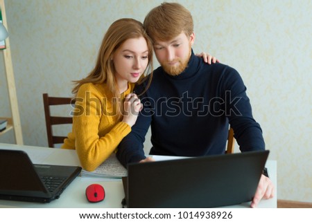 beautiful and young couple man and woman working on laptop at home