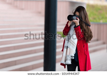 Attractive young woman taking pictures outdoors