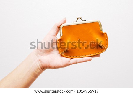 Hand holding empty wallet on white.