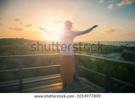Muslim woman open arm and rise hands up on beautiful nature view. Islam pray on hill fasting ramadan day background. allah support quran standing enjoying sunset concept believe world wisdom 2018 Royalty-Free Stock Photo #1014977809