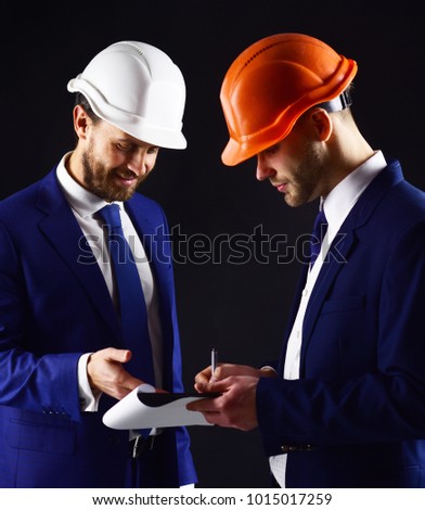 Engineers with smiling faces look at documents. Client and architect with architectural project. Successful project, happy client, profession concept. Successful building and profitable deal.
