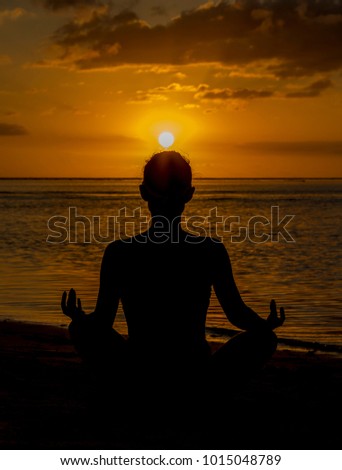 Young girl stay in lotus position on sunset